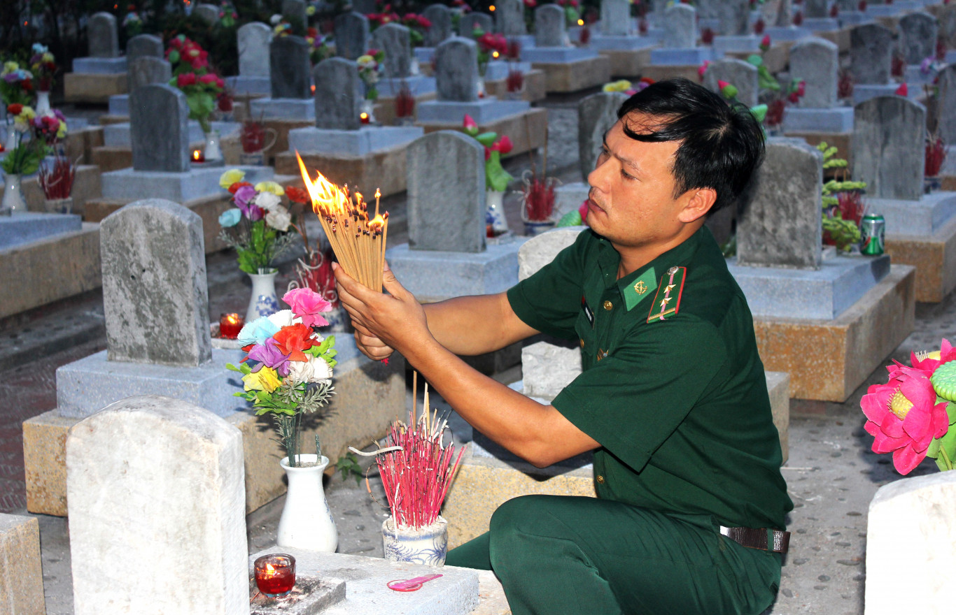 Thắp nén nhang viếng người đã khuất - Ảnh: H.T.T